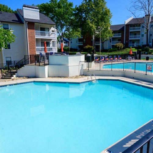 a swimming pool with a deck and trees in the background